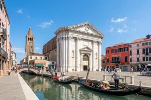 Da Vinci Interactive Museum - Venedig - Außenansicht: Die klassizistische Fassade der Kirche San Barnaba am Campo San Barnaba mit Gondeln auf dem Kanal