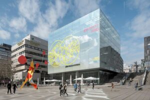 Kunstmuseum Stuttgart - Außenansicht: Moderner Glaskubus am Kleinen Schlossplatz mit Jubiläumsbeschriftung Doppelkäseplatte