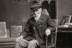 Pierre-Auguste Renoir: Ein historisches Porträtfoto des französischen impressionistischen Malers in seinem Atelier, sitzend in einem Korbsessel